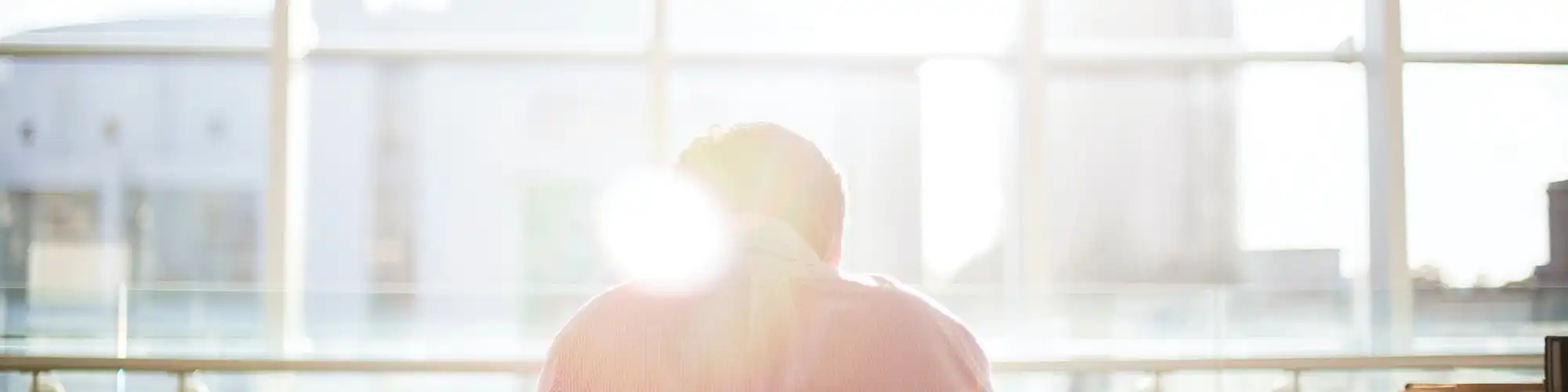Homme souffrant des rayons du soleil dans un bureau, par Bethany Legg.