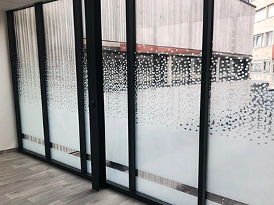 Film adhésif design à motif pixel posé par Énergère sur les vitrages d'un ERP, à Angers.