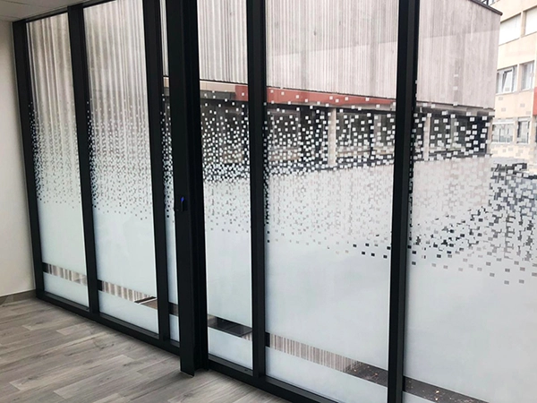 Film adhésif design à motif pixel posé par Énergère sur les vitrages d'un ERP.