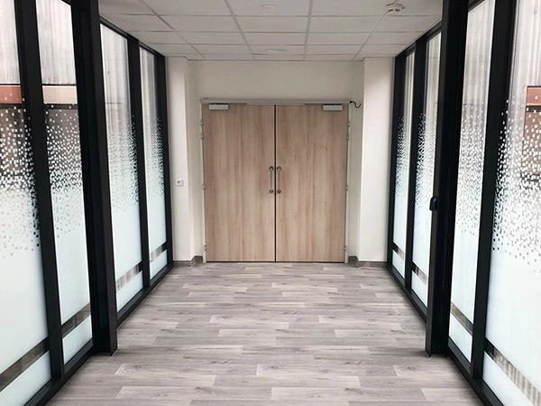 Film adhésif design à motif pixel posé par Énergère sur les vitrages d'un ERP.