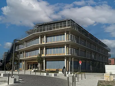 Façades côté rue du groupe scolaire Yvonne Kerzrého, dans la ZAC Les Groues, à Nanterre, avec les toiles des stores enrouleurs baissées.