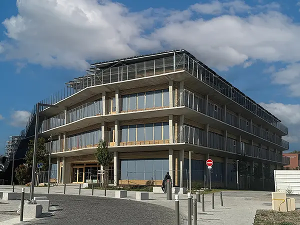 Façades côté rue du groupe scolaire Yvonne Kerzrého, dans la ZAC Les Groues, à Nanterre, avec les toiles des stores enrouleurs baissées.
