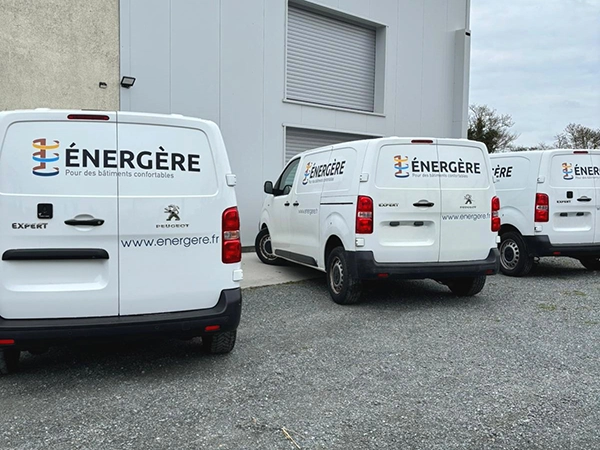 Véhicules utilitaires Énergère stationnés devant l'entrepôt de l'entreprise.